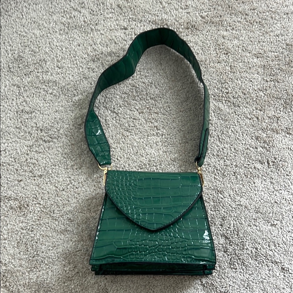 Small green purse w/ gold chain attachment.